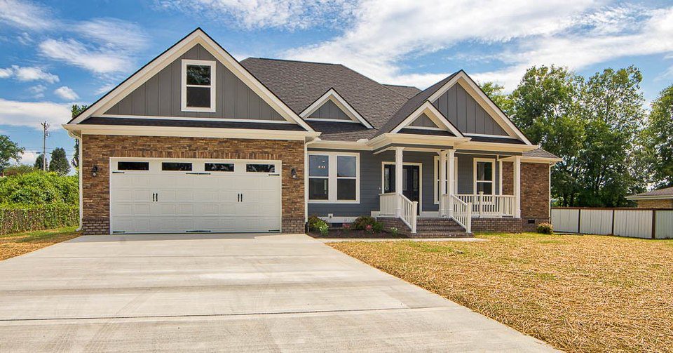 Modern suburban house with a two-car garage and a spacious driveway.